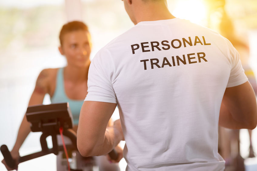 Personal trainer on weights lifting training with  client